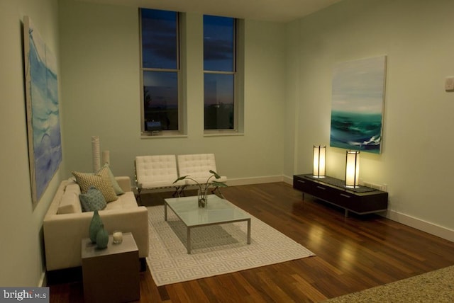 living area with baseboards and wood finished floors