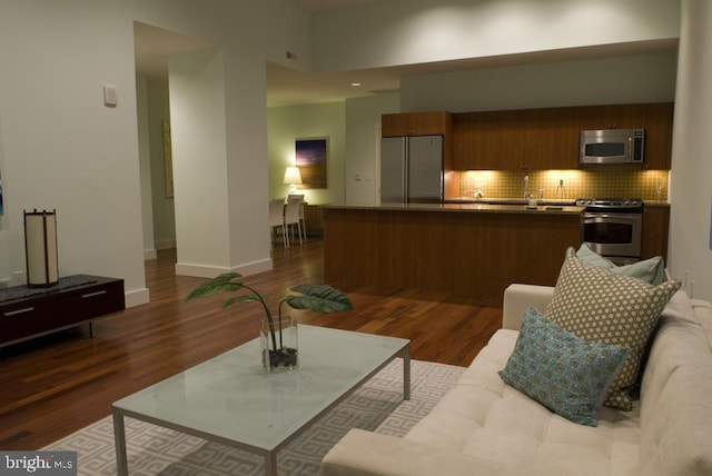 living room with baseboards and dark wood-type flooring