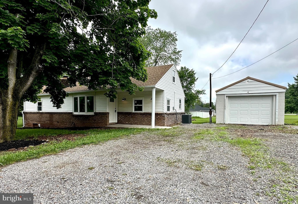 7679 Altland Ave, Abbottstown, PA 17301 - view of home's exterior featuring driveway, a garage, an outdoor structure, brick siding, and cooling unit