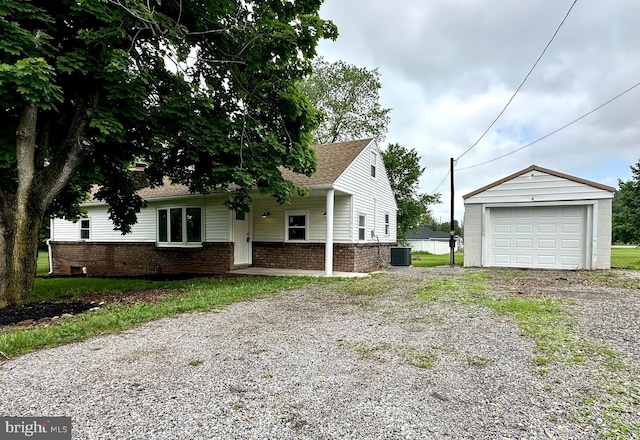 view of home's exterior featuring driveway, a garage, an outdoor structure, brick siding, and cooling unit
