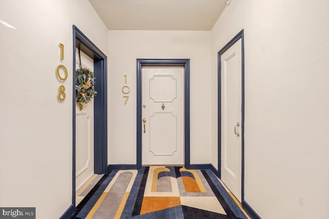 doorway with inlaid floor details and baseboards