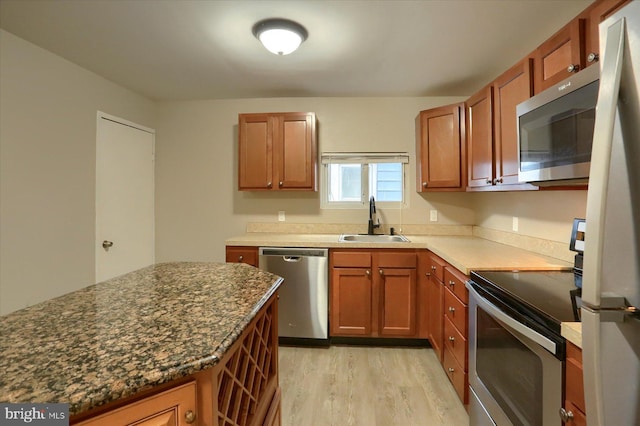 235 Wyoming Ave, Enola, PA 17025 - kitchen featuring stainless steel appliances, a sink, light wood-style floors, and brown cabinetry