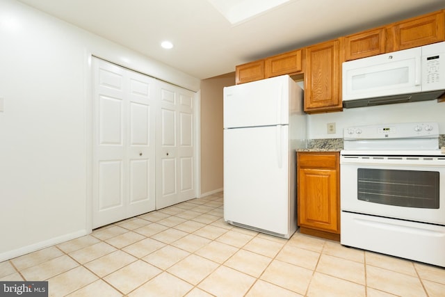 kitchen featuring recessed lighting, light tile patterned floors, baseboards, white appliances, and brown cabinets