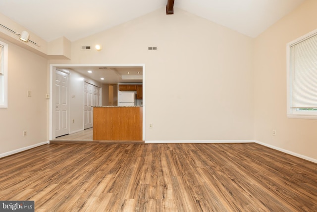 unfurnished living room with high vaulted ceiling, light wood-type flooring, visible vents, and beam ceiling