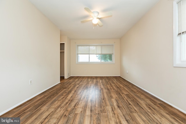 empty room with ceiling fan, baseboards, and wood finished floors