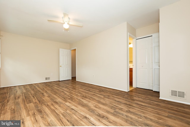 empty room featuring baseboards, ceiling fan, visible vents, and wood finished floors