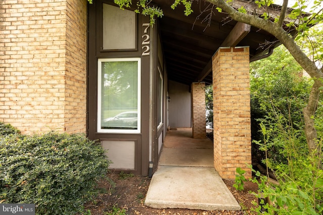 doorway to property featuring brick siding