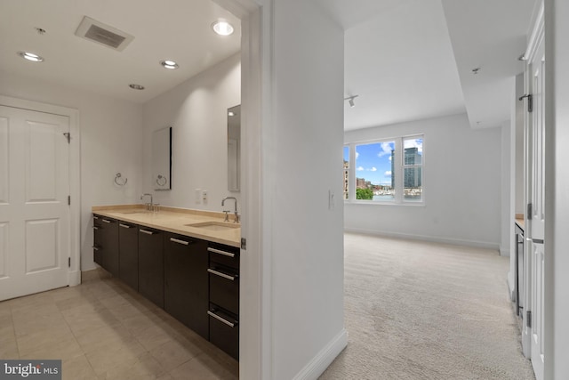 bathroom featuring baseboards, double vanity, and recessed lighting