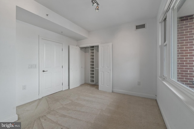 unfurnished bedroom featuring carpet flooring, baseboards, and a closet