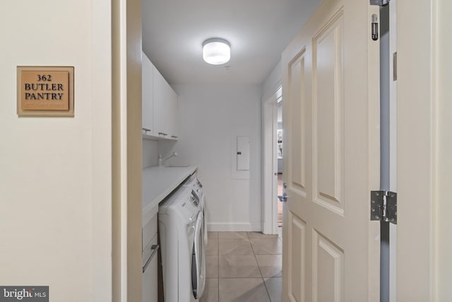 washroom with cabinet space, independent washer and dryer, light tile patterned floors, and baseboards