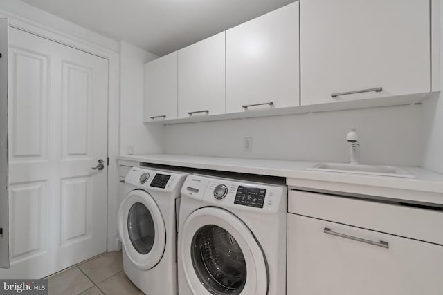 clothes washing area featuring cabinet space, washer and dryer, and light tile patterned floors