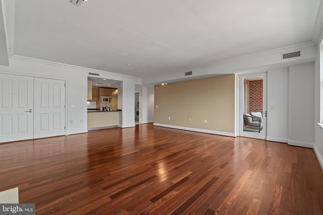 unfurnished living room featuring crown molding, wood finished floors, and baseboards