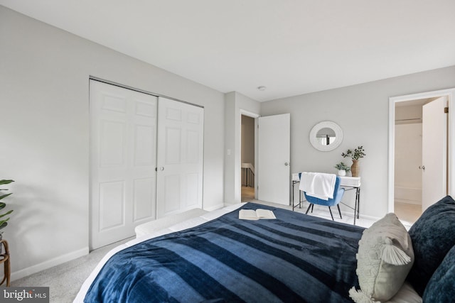 carpeted bedroom with baseboards, a closet, and ensuite bath