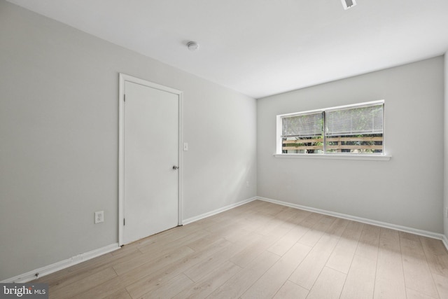 empty room featuring baseboards and wood finished floors