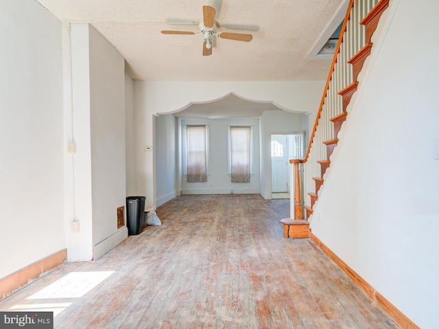 2030-32 E Somerset St, Philadelphia, PA 19134 - unfurnished living room with wood finished floors, ceiling fan, stairs, a textured ceiling, and arched walkways