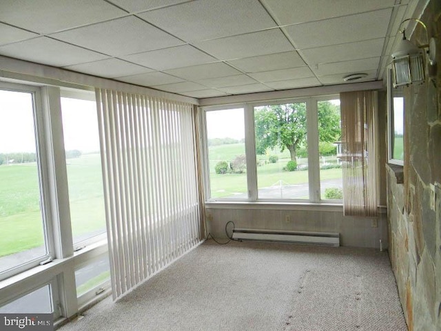 unfurnished sunroom featuring a paneled ceiling, a baseboard radiator, and carpet flooring