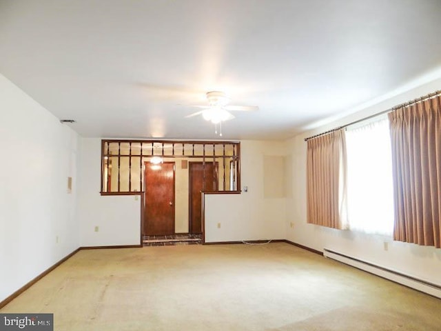 empty room with baseboards, a ceiling fan, and a baseboard heating unit