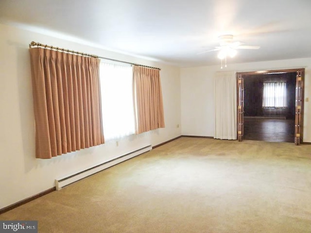 spare room with ceiling fan, carpet floors, baseboards, and a baseboard heating unit