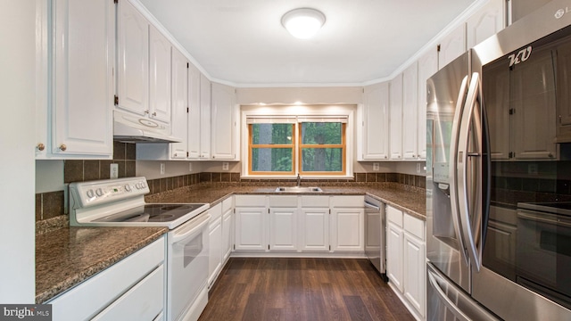 kitchen with appliances with stainless steel finishes, under cabinet range hood, a sink, dark wood-style flooring, and white cabinets