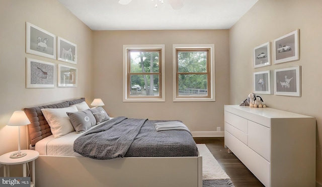 bedroom with dark wood-style flooring, baseboards, and a ceiling fan