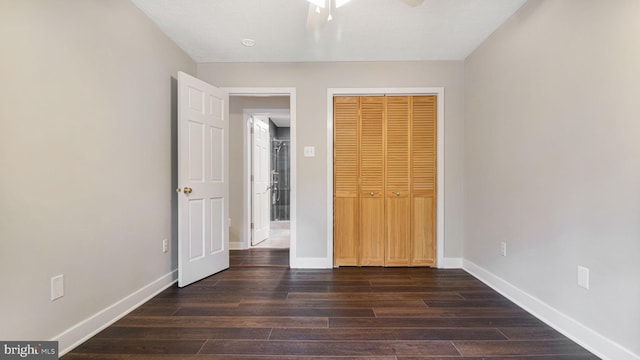 unfurnished bedroom featuring wood finished floors, baseboards, a closet, and a ceiling fan