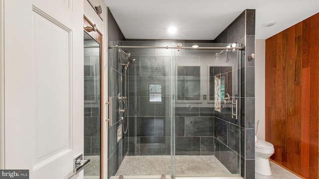 full bath with toilet, a shower stall, and tile patterned floors
