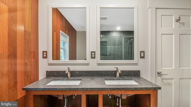 full bathroom with an enclosed shower and double vanity
