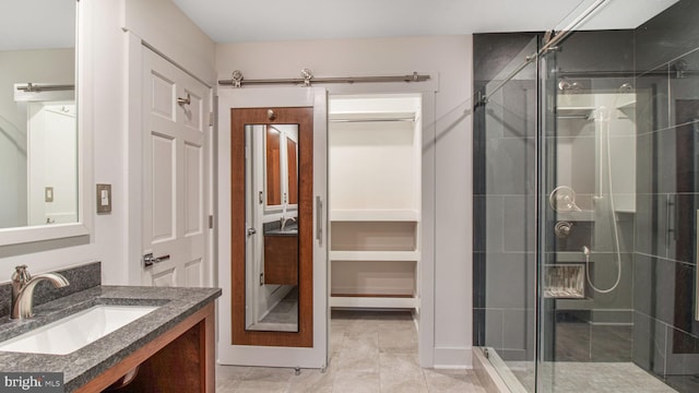 full bath with a stall shower, vanity, and tile patterned floors