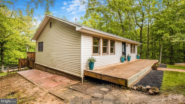 view of property exterior with a deck and fence