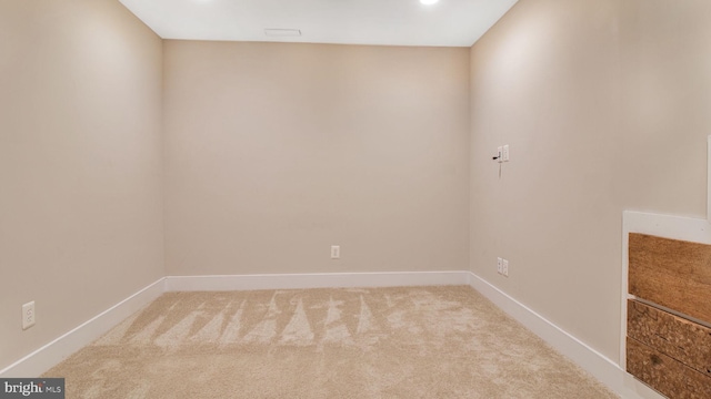 unfurnished room featuring light colored carpet and baseboards