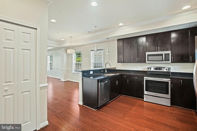 5823 Field Pl NE, Washington, DC 20019 - kitchen featuring a sink, a peninsula, stainless steel appliances, ornamental molding, and dark countertops
