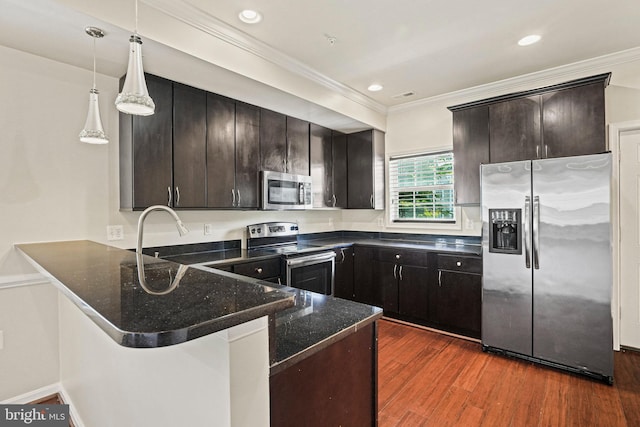 5823 Field Pl NE, Washington, DC 20019 - kitchen featuring a peninsula, crown molding, dark wood-type flooring, stainless steel appliances, and dark stone counters