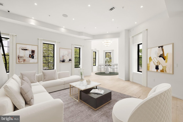 living room with light wood-style flooring, a chandelier, and recessed lighting