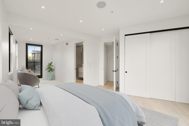 bedroom featuring light wood-type flooring, recessed lighting, and a closet