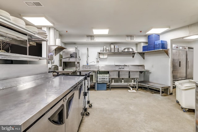 kitchen with stainless steel counters, concrete floors, and open shelves