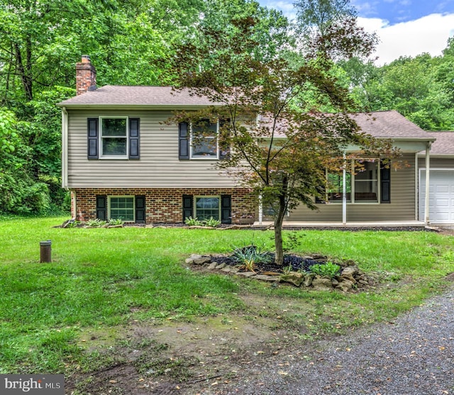 612 Park St, Manchester, PA 17345 - view of front facade with a front lawn, a chimney, and an attached garage