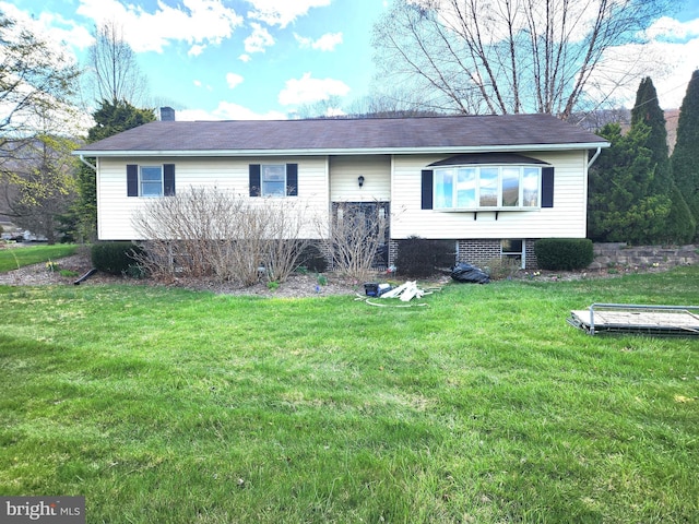 split foyer home with a front lawn and a chimney
