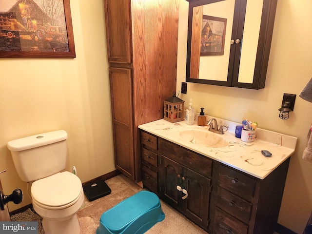 bathroom featuring vanity, toilet, baseboards, and tile patterned floors