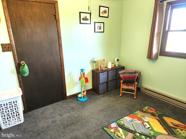 interior space with carpet, baseboards, and a baseboard heating unit