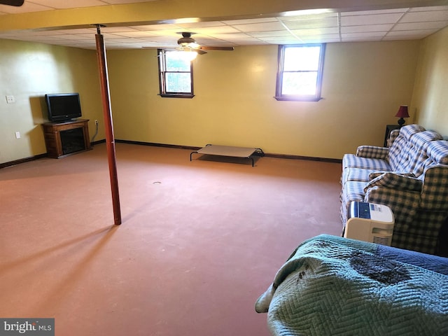 below grade area with carpet flooring, baseboards, and a drop ceiling