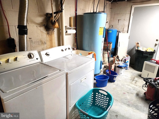 clothes washing area with washer and clothes dryer and water heater