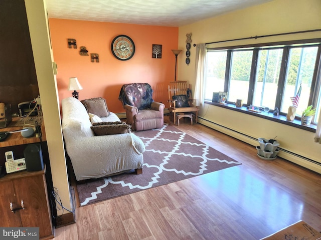 living room with baseboard heating and wood finished floors