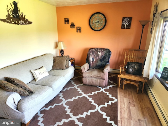 living area featuring wood finished floors and a baseboard heating unit