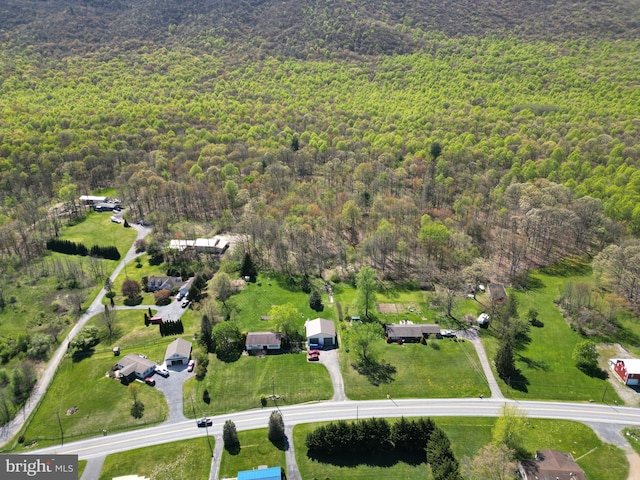 drone / aerial view featuring a wooded view