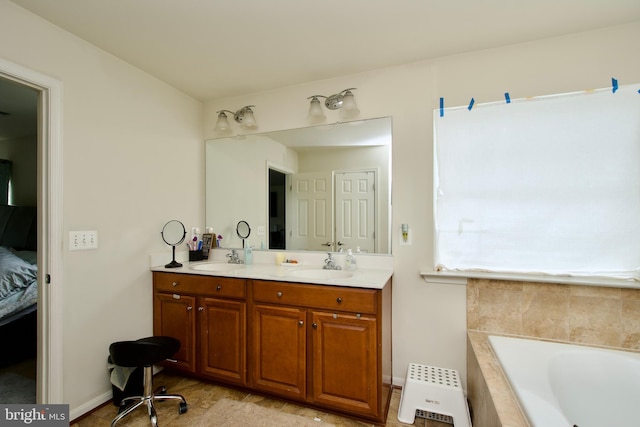 ensuite bathroom featuring double vanity, tiled tub, and baseboards
