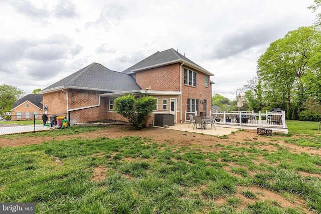 back of property featuring brick siding, a deck, cooling unit, and a patio
