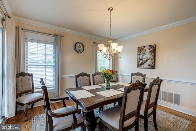 dining room featuring a chandelier, ornamental molding, and wood finished floors