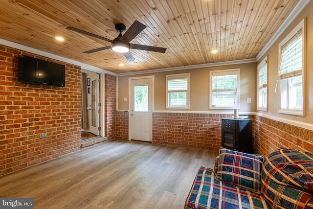 living area featuring brick wall, ornamental molding, wood ceiling, wood finished floors, and ceiling fan