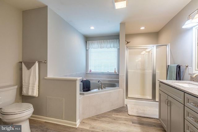 full bath with a stall shower, wood finished floors, vanity, and recessed lighting