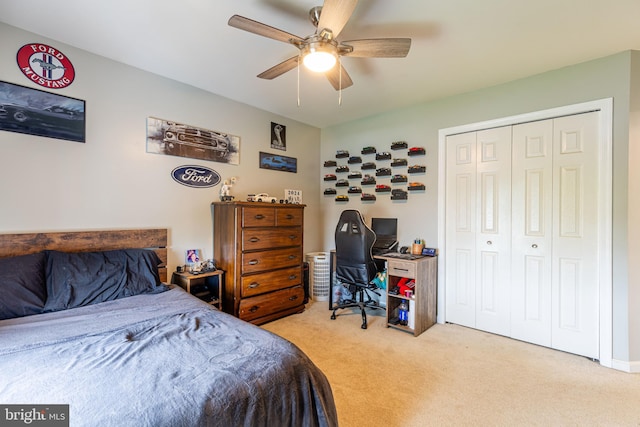 bedroom with light carpet, a closet, a ceiling fan, and a desk
